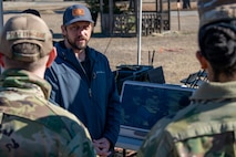 A photo of a man speaking in a group.