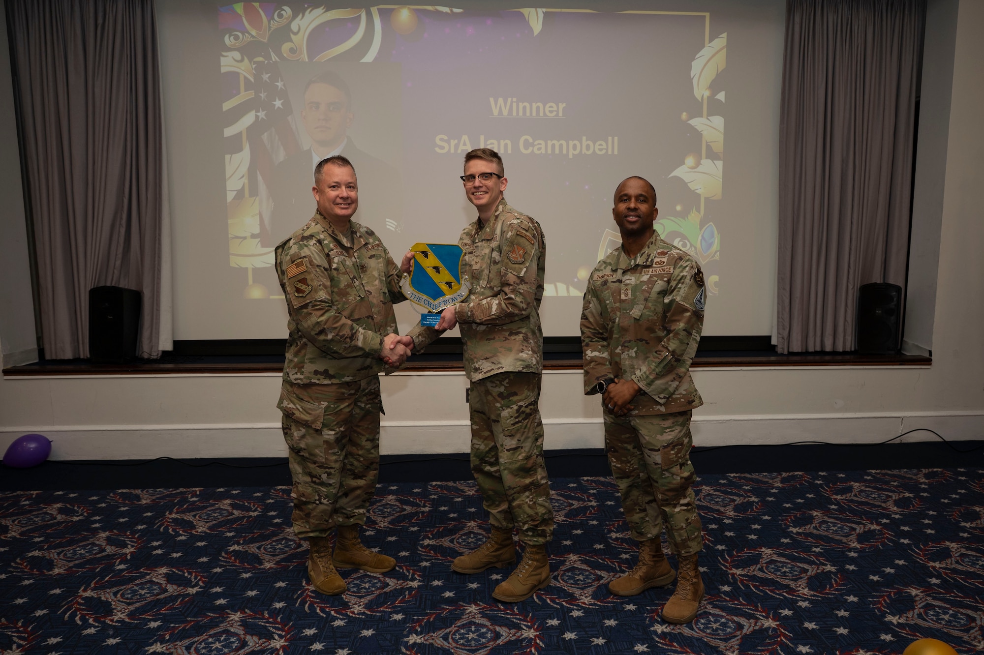 An award winner poses with wing leadership.