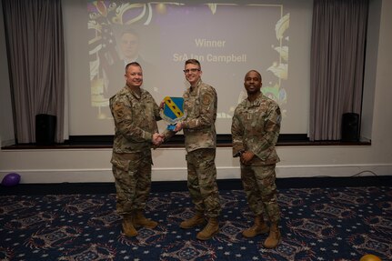 An award winner poses with wing leadership.