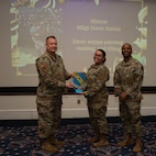 An award winner poses with wing leadership.