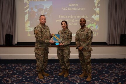 An award winner poses with wing leadership.