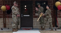 Base leadership and Security Forces Squadron cut ribbon outside of new kennel facility.