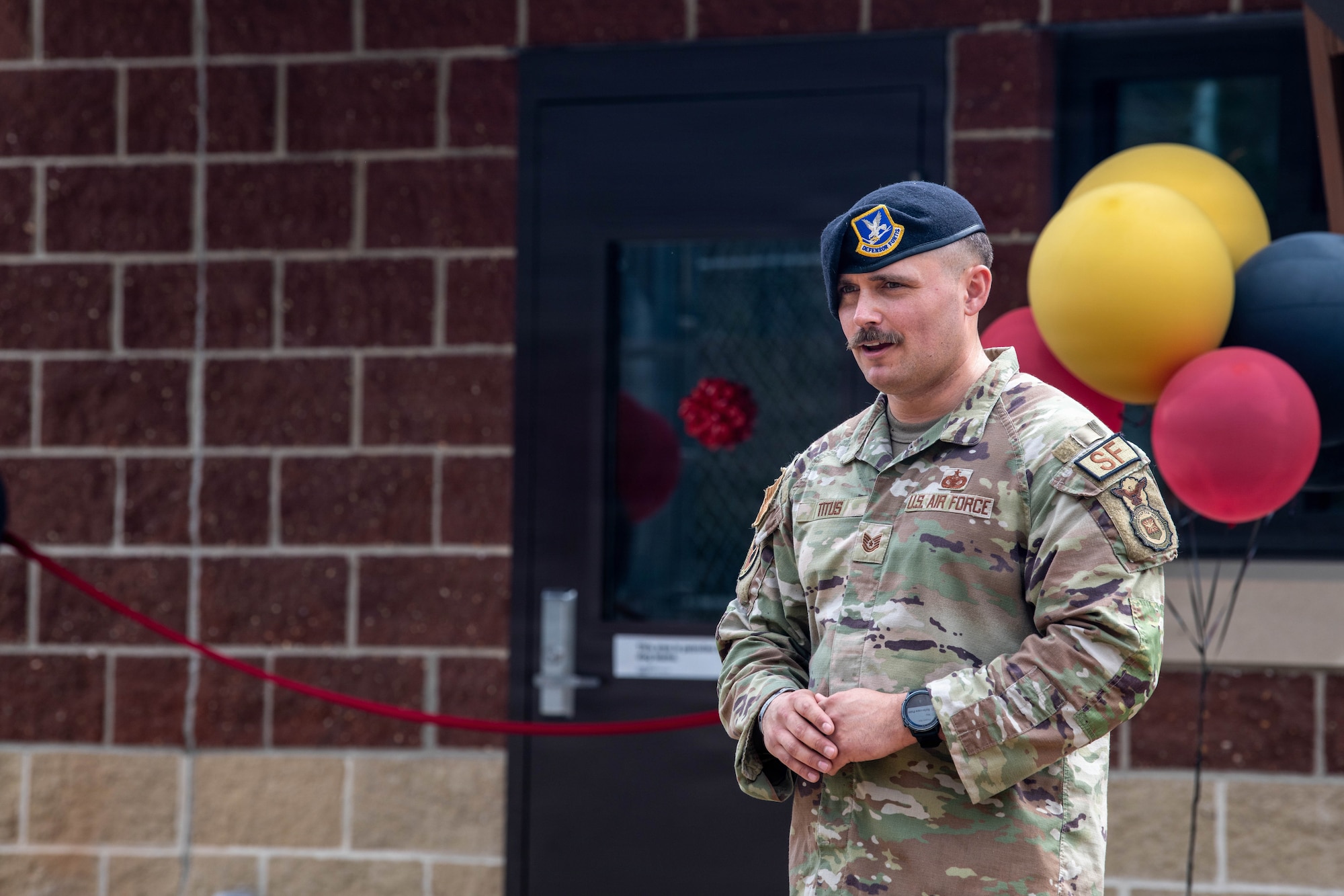 Airman speaks to a crowd outside of the kennel facility.
