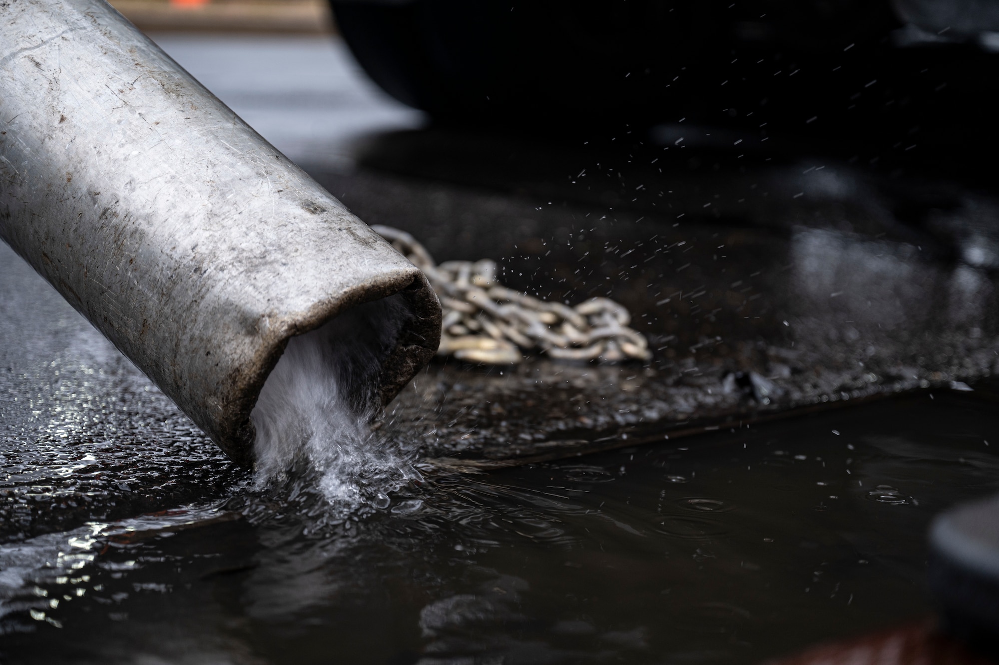 A hydrovac truck vacuums rainfall to clear the road and prevent flooding during a sinkhole repair at Joint Base McGuire-Dix-Lakehurst, N.J., Feb. 20, 2026. A hydrovac truck is a specialized vehicle used to remove debris and water. (U.S. Air Force photo by Airman 1st Class Francine D. Martin)