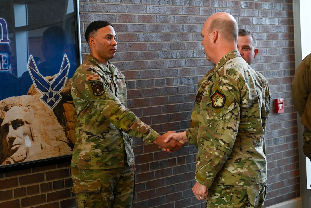 U.S. Air Force Gen. S.L. Davis, commander of Air Force Global Strike Command, presents a challenge coin to a 28th Bomb Wing Airman for outstanding duty performance at Ellsworth Air Force Base, S.D., Feb. 18, 2026.