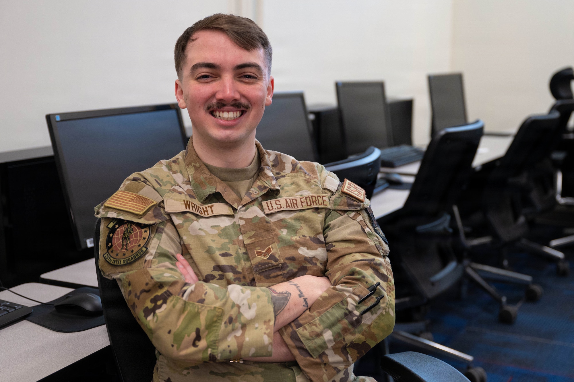 Airman poses for a photo in a computer lab.