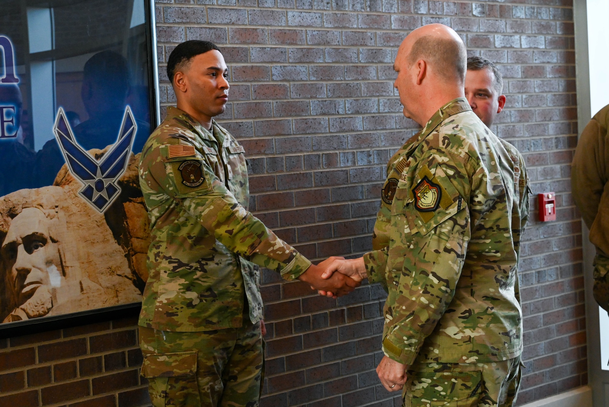 U.S. Air Force Gen. S.L. Davis, commander of Air Force Global Strike Command, presents a challenge coin to a 28th Bomb Wing Airman for outstanding duty performance at Ellsworth Air Force Base, S.D., Feb. 18, 2026.