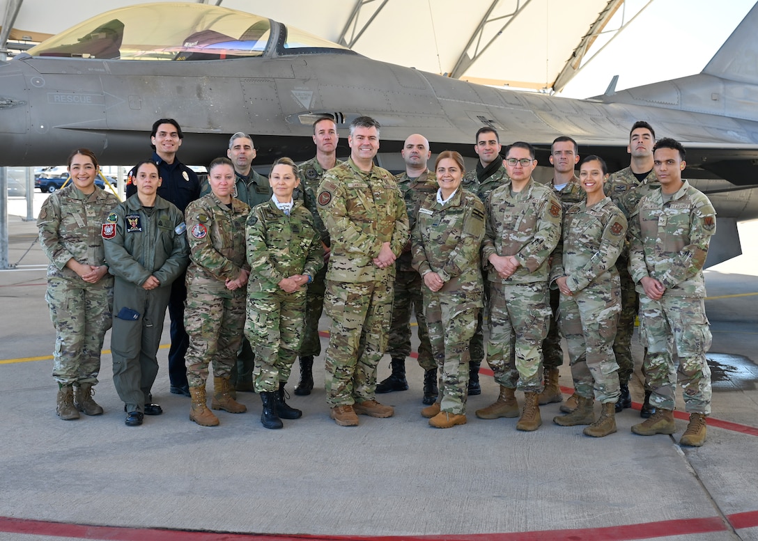 U.S. Air Force Col. Brian Gavitt, Air Forces Southern command surgeon, center, and the Fuerza Aérea Argentina (FAA) pose for a photo in front of an F-16 Fighting Falcon aircraft, at Morris Air National Guard Base, Arizona, Jan. 9, 2026. During the visit, AFSOUTH connected the FAA delegation with subject matter experts across multiple mission areas, including infrastructure, weapons systems and aerospace medicine, to support the development of a comprehensive and sustainable F-16 program for the partner nation. (U.S. Air Force photo by Staff Sgt. Abbey Rieves)