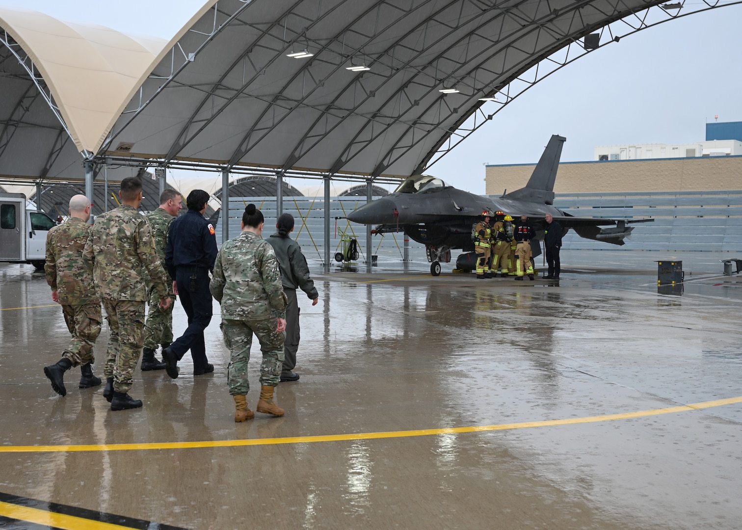 Members of the Fuerza Aérea Argentina (FAA) walk towards an F-16 Fighting Falcon aircraft at Morris Air National Guard Base, Arizona, Jan 7, 2026. During the visit, the FAA delegation met with subject matter experts across multiple mission areas, including infrastructure, weapons systems and aerospace medicine, to support their development of a comprehensive and sustainable F-16 program. (U.S. Air Force photo by Staff Sgt. Abbey Rieves)