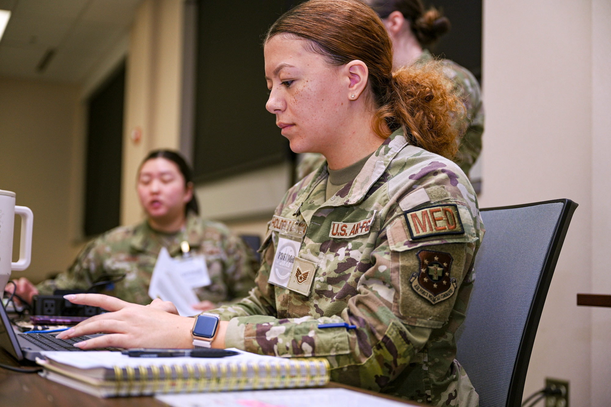 U.S. Air Force Staff Sgt. Lila Holden De La Rosa, force support noncommissioned officer in charge with the Bolling Medical Squadron, completes administrative tasks during a Personnel Deployment Function line at Joint Base Anacostia-Bolling, Washington, D.C., Jan. 9, 2026. The BMS medical team ensured all deployable personnel in the PDF line were medically ready prior to deployments.  (U.S. Air Force photo by Airman 1st Class Shanel Toussaint)