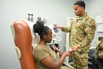 U.S. Air Force Senior Airman Jaelen Myrick, right, medical technician with the Bolling Medical Squadron, administers a blood pressure and pulse test to Airman 1st Class Atabongankeng Fonkem at Bolling Medical Squadron, Joint Base Anacostia-Bolling, Washington, D.C., Feb. 20, 2026. This test ensured Fonkem’s vitals were within a healthy range to detect silent illnesses early, improve long term health outcomes and provide a baseline for delivering future care. (U.S. Air Force photo by Airman 1st Class Shanel Toussaint)
