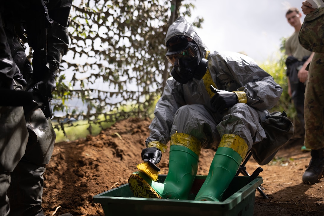 U.S. Navy HM3 Spencer Livingston, a corpsman with 12th Littoral Logistics Battalion, 12th Marine Littoral Regiment, 3rd Marine Division, decontaminates gear during a Chemical, Biological, Radiological, and Nuclear decontamination training as part of Resolute Dragon 25 at Oyanohara Maneuver Area, Oita Prefecture, Japan, Sept. 17, 2025. Resolute Dragon 25 is an annual bilateral exercise in Japan that strengthens the command, control, and multi-domain maneuver capabilities of U.S. Marines in III Marine Expeditionary Force and Japan Self-Defense Force personnel, with a focus on controlling and defending key maritime terrain. Livingston is a native of Washington. (U.S. Marine Corps photo by Lance Cpl. Robert Blanks)