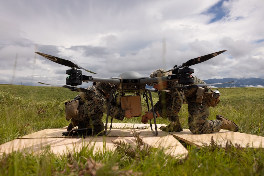 U.S. Marine Corps Cpl. Jasmine Menoscal, left, a logistics specialist, and Capt. Kyle Emrick, the company commander of Bravo Company,12th Littoral Logistics Battalion, 12th Marine Littoral Regiment, 3rd Marine Division, attach supplies to a Tactical Resupply Unmanned Aircraft System during Resolute Dragon 25 at Oyanohara Maneuver Area, Oita Prefecture, Japan, Sept. 17, 2025. Resolute Dragon 25 is an annual bilateral exercise in Japan that strengthens the command, control, and multi-domain maneuver capabilities of U.S. Marines in III Marine Expeditionary Force and Japan Self-Defense Force personnel, with a focus on controlling and defending key maritime terrain. Menoscal is a native of New York (U.S. Marine Corps photo by Lance Cpl. Robert Blanks)