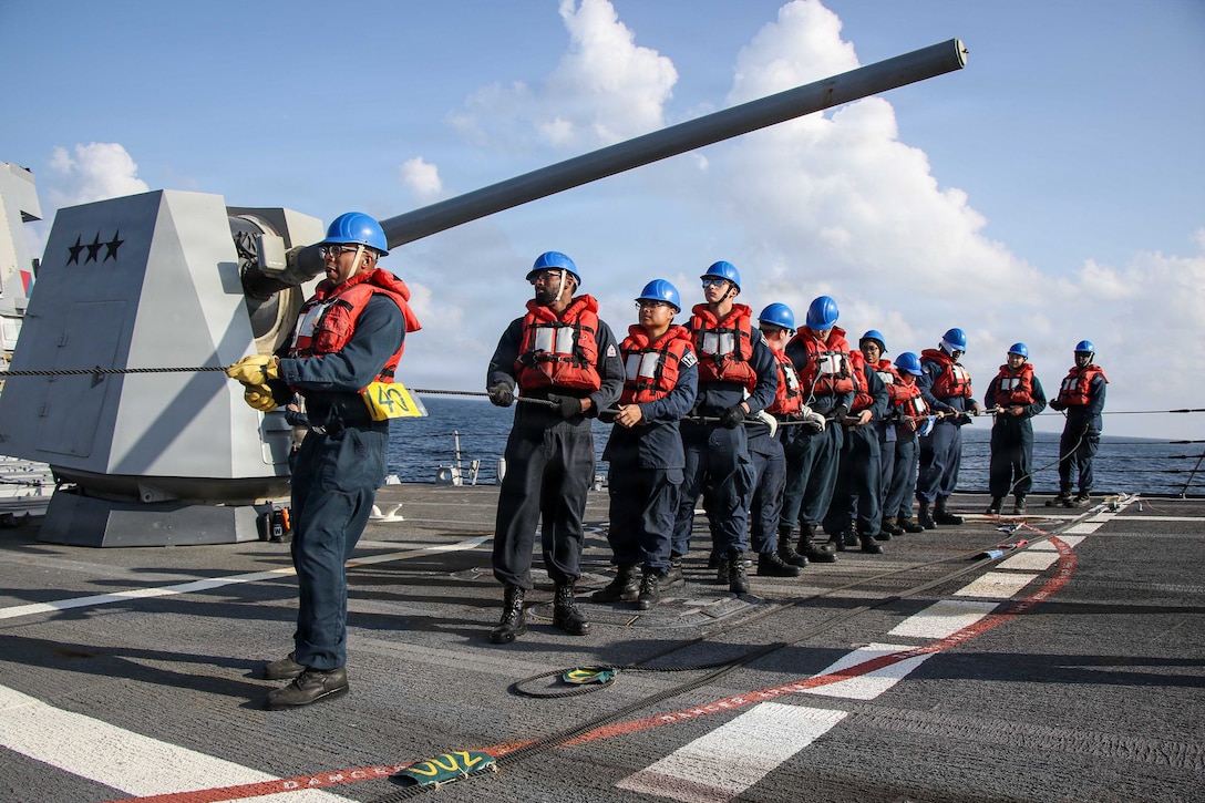 U.S. Sailors man a phone-and-distance line on the forecastle of Arleigh Burke-class guided-missile destroyer USS Frank E. Petersen Jr. (DDG 121), during a replenishment-at-sea in the Arabian Sea, Feb. 18, 2026. Frank E. Peterson Jr. is deployed to the U.S. 5th Fleet area of operations to support maritime security and stability in the Middle East. (U.S. Navy photo by Mass Communication Specialist 2nd Class Christian Kibler)