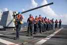 U.S. Sailors man a phone-and-distance line on the forecastle of Arleigh Burke-class guided-missile destroyer USS Frank E. Petersen Jr. (DDG 121), during a replenishment-at-sea in the Arabian Sea, Feb. 18, 2026. Frank E. Peterson Jr. is deployed to the U.S. 5th Fleet area of operations to support maritime security and stability in the Middle East. (U.S. Navy photo by Mass Communication Specialist 2nd Class Christian Kibler)
