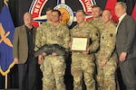 Soldiers from the 28th Infantry Division who won the innovation category at the U.S. Army’s inaugural Best Drone Warfighter Competition receive their award from Secretary of the Army Dan Driscoll, right, Feb. 19, 2026, in Huntsville, Alabama. At left is retired Brig. Gen. Timothy J. Edens, senior vice president of the Army Aviation Association of America. Courtesy photo.