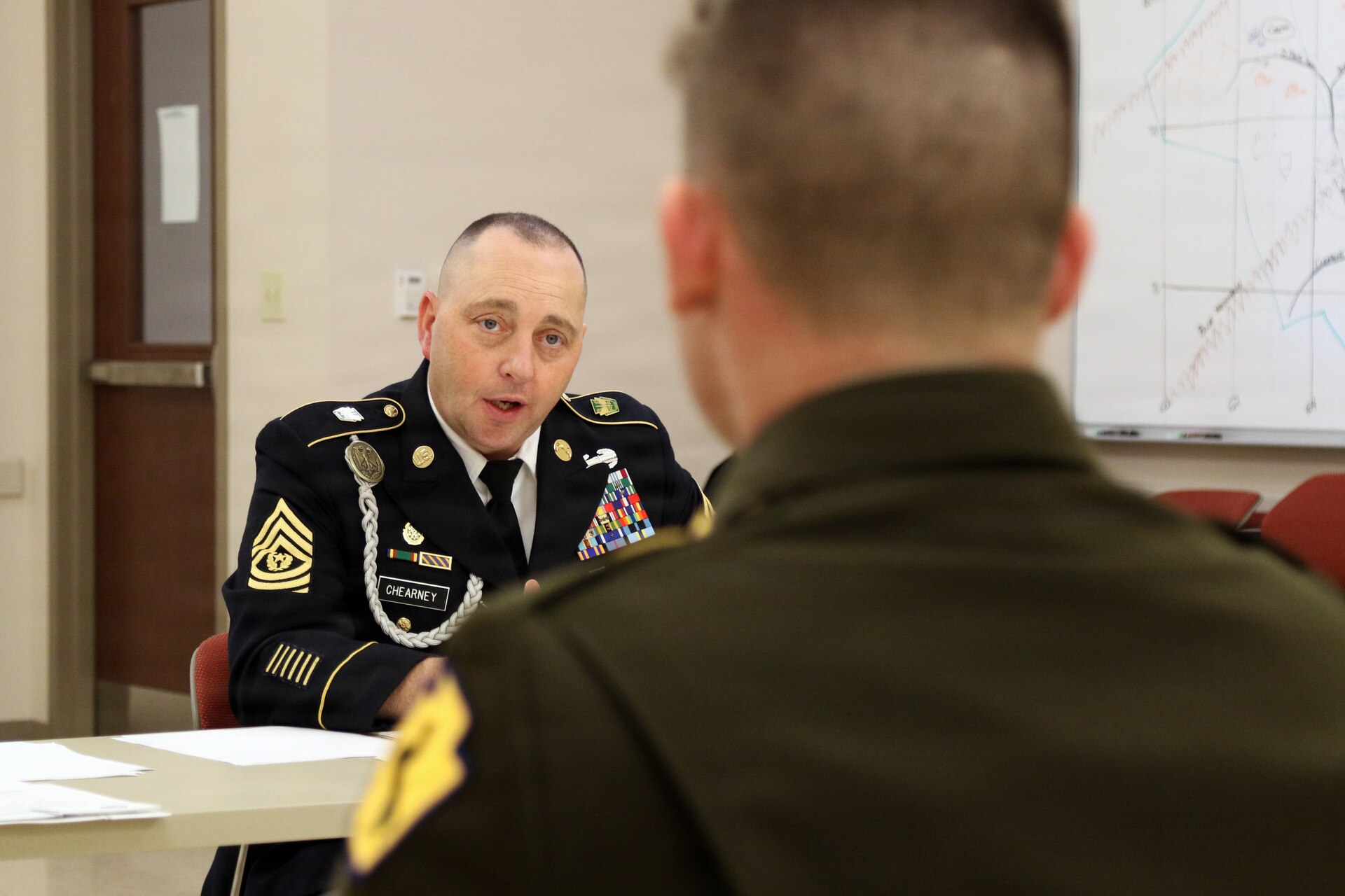 U.S. Army Command Sgt. Maj. Joseph Chearney (left) with the 165th Military Police Battalion, 55th Maneuver Enhancement Brigade, Pennsylvania Army National Guard asks a question to Spc. Ethan Debockler, a military police Soldier with the 28th Military Police Company, during a brigade appearance board in Scranton, Pa. Feb. 21, 2026. (U.S. Army National Guard photo by Sgt. 1st Class Shane Smith)