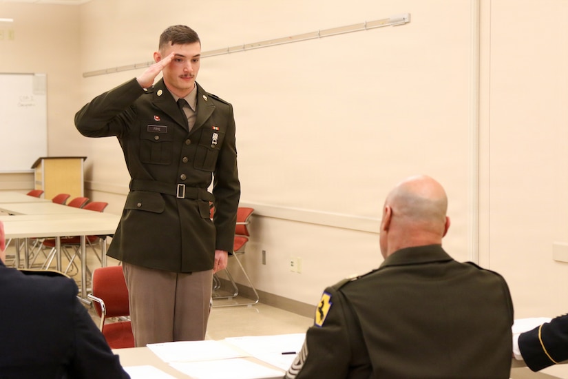 U.S. Army Spc. Todd Frye (left), assigned to the 192nd Firefighter Detachment, 55th Maneuver Enhancement Brigade, Pennsylvania Army National Guard reports to Command Sgt. Maj. Evan Melendez, president of the board, during a brigade appearance board in Scranton, Pa. Feb. 21, 2026. (U.S. Army National Guard photo by Sgt. 1st Class Shane Smith)
