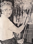 Artist posing while painting a swamp scene.