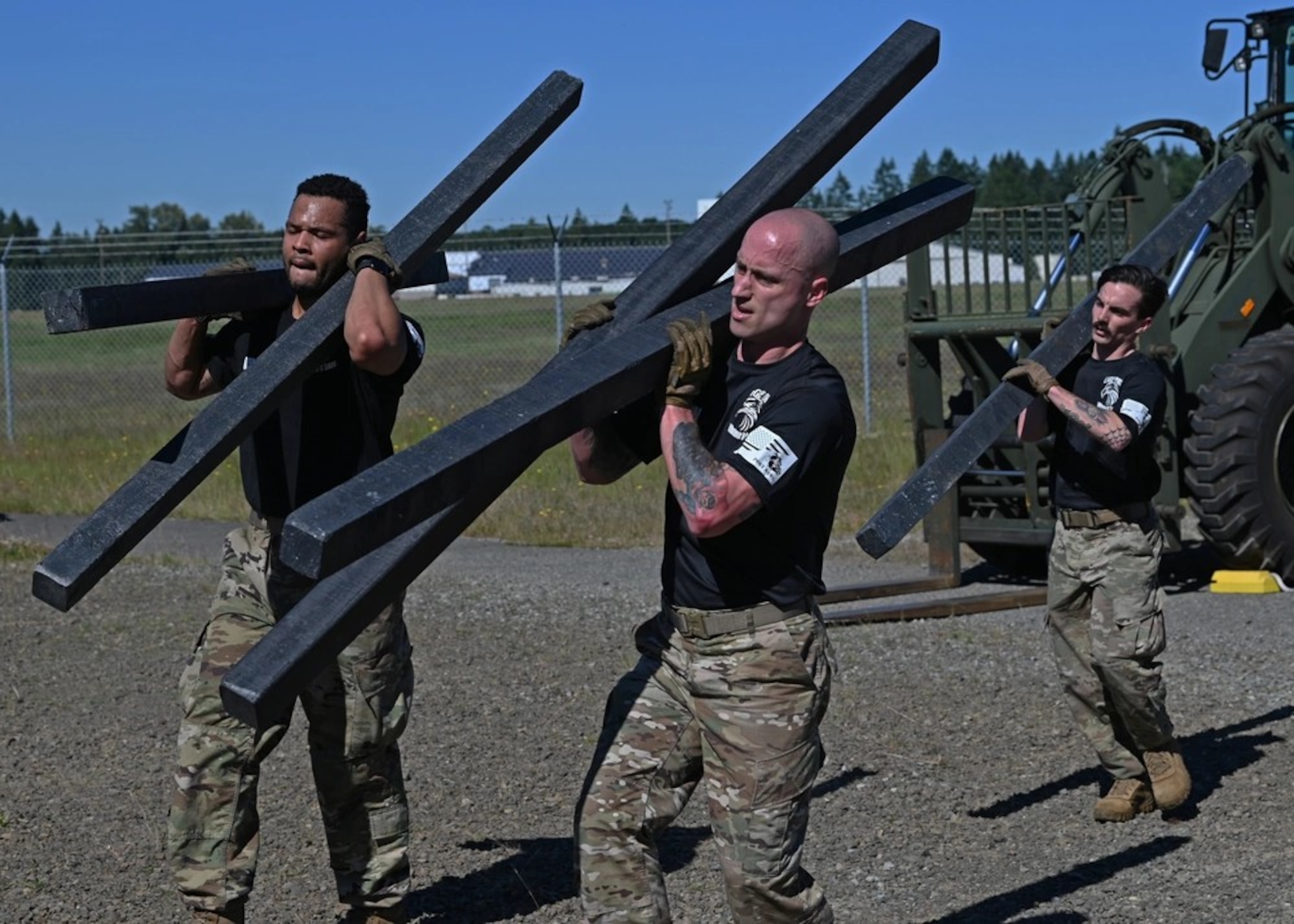 U.S. Air Force Staff Sgt. Ashley Royal, left, ramp operations supervisor, Tech. Sgt. Michael Harrison, center, air terminal operation center senior controller, and Staff Sgt. Seth Dolan, air terminal operation center information controller, all with the 62d Aerial Port Squadron, carry posts on and off a forklift during the Port Dawg Rodeo at Joint Base Lewis-McChord, Washington, June 24, 2022.