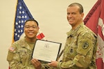 Soldier presents a certificate to a recent 68W graduate