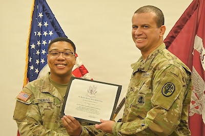 Soldier presents a certificate to a recent 68W graduate