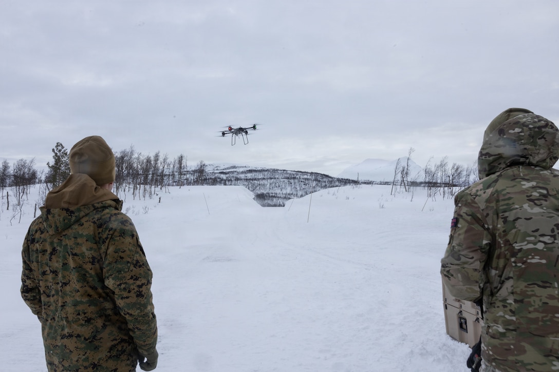 U.S. Marine Corps 2nd Lt. Travis Kring, left, an intelligence officer with Combat Logistics Battalion 6, Combat Logistics Regiment 2, 2nd Marine Logistics Group, watches a U.K. Royal Marine pilot the T-150 uncrewed aerial system in Setermoen, Norway, Feb. 17, 2026. The demonstration highlighted the differences between the resupply unmanned aircraft systems used by the U.K. Royal Marines and the U.S. Marine Corps. A key component of NATO's enhanced vigilance activity Arctic Sentry, exercise Cold Response 26 is a Norwegian-led winter military exercise designed to enhance collective defense capabilities and ensure U.S. readiness to rapidly deploy and seamlessly operate alongside NATO Allies in challenging arctic conditions. Kring is a native of Arizona. (U.S. Marine Corps photo by Cpl. Apollo Wilson)