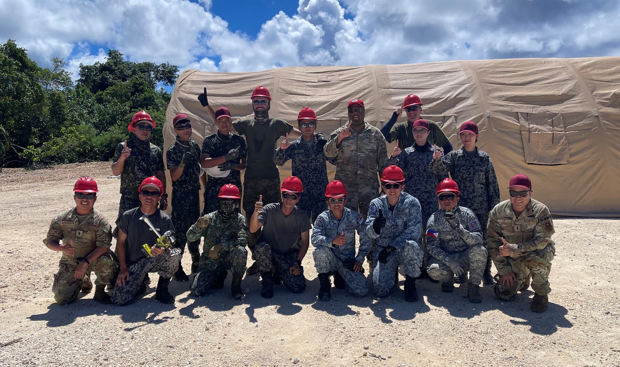 LEAP Scholars 1st Lt. Masahito Nishimura (bottom far left) and 1st Lt. Yu Lei (bottom far right) pose with military members from partner allies, a member of Red Horse, and United States Air Force interpreters after a tent building event during the recent Allies & Partners Engineer Summit in the INDOPACOM AOR.