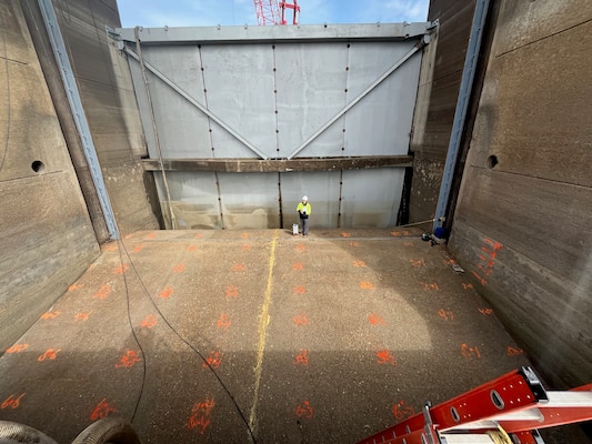 Rebekah Lee, research geophysicist with ERDC's Geotechnical and Structures Lab, standing beside the gravimeter used to accurate measure gravity in the dewatered bay.