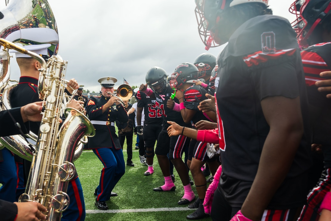 U.S. Marine Corps 2nd Marine Division Band performs for the Northeast High School football team before a Northeast vs George Washington football game at Northeast High School during Navy Marine Corps 250 in Philadelphia, Pennsylvania, Oct. 11, 2025
