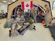 In September 2025, scientists from the Walter Reed Army Institute of Research—West participated in a collaborative effort with Baylor University and U.S. Army Combat Capabilities Development Command to collect data measuring physiological and psychological factors affecting combat medic performance during simulated patient encounters at Bold Quest 2025. Pictured are combat medics from United Kingdom coalition partners, following initial point of injury care, preparing to hand off a patient to the Role 1 care medical team. This photo has been edited.