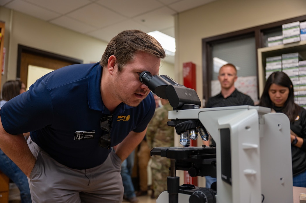 A man looks through a microscope in a laboratory.