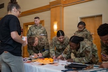 Airmen from Joint Base Charleston write letters and discuss the importance of teenage dating violence awareness.