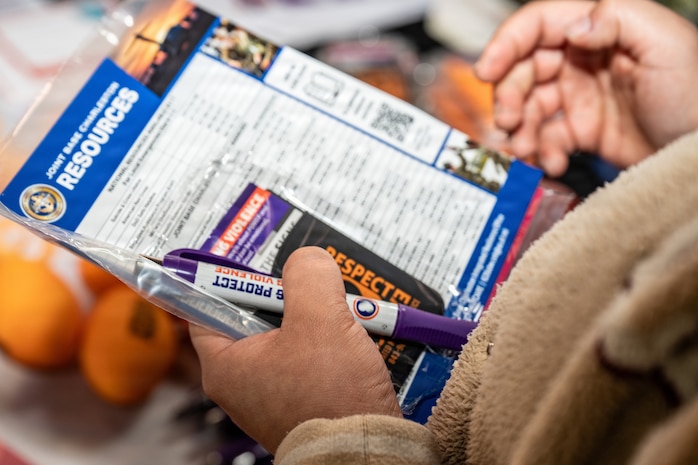 An Airman from Joint Base Charleston holds a resource manual with information on teenage dating.