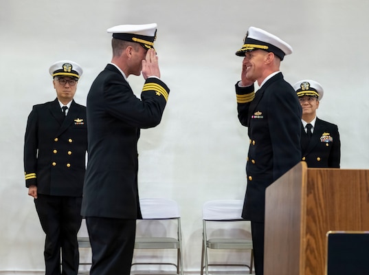 U.S. Navy Cmdr. Paul Archer, off-going commanding officer of Arleigh Burke-class guided-missile destroyer USS Preble (DDG 88), center left, relieves his command to Cmdr. Andrew Vann, center right, during a change of command ceremony at Commander, Fleet Activities Yokosuka Headquarters’ C-2 Auditorium in Yokosuka, Japan, Feb. 20, 2026.