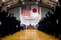 U.S. Navy Cmdr. Paul Archer, off-going commanding officer of Arleigh Burke-class guided-missile destroyer USS Preble (DDG 88), center, delivers remarks to guests and assembled crew members during a change of command ceremony at Commander, Fleet Activities Yokosuka Headquarters’ C-2 Auditorium in Yokosuka, Japan, Feb. 20, 2026.