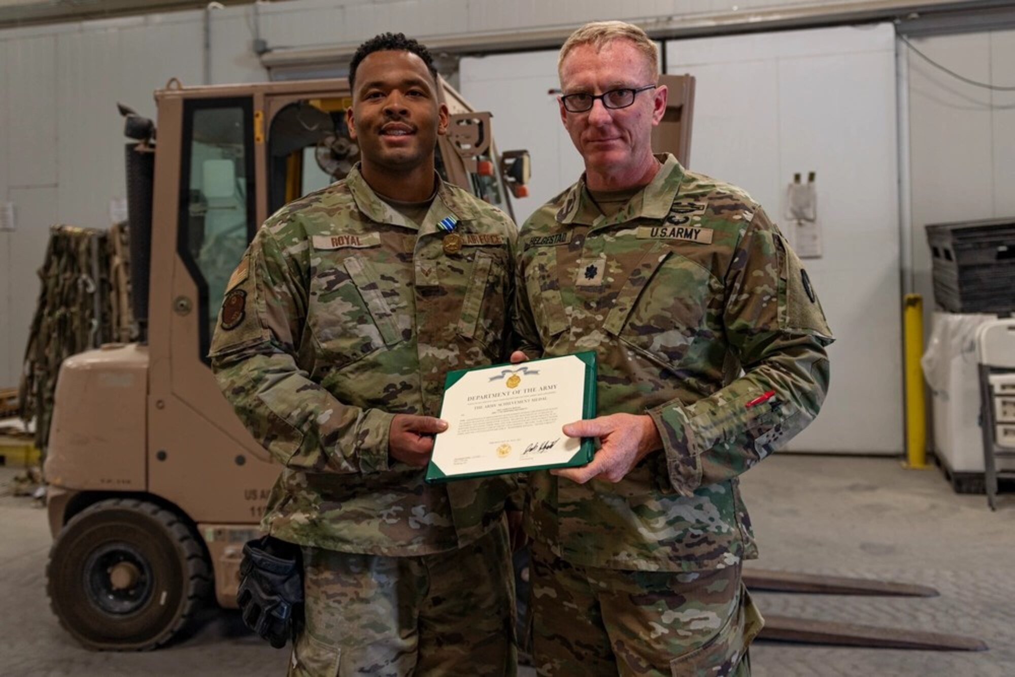 U.S. Air Force Senior Airman Ashley Royal, left, 386th Expeditionary Logistics Readiness Squadron, receives an Army Achievement Medal at Ali Al Salem Air Base, Kuwait, June 4, 2021.