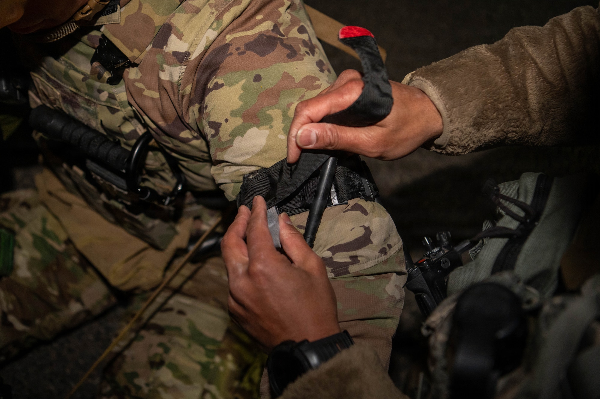 Airman applies tourniquet to wingman.