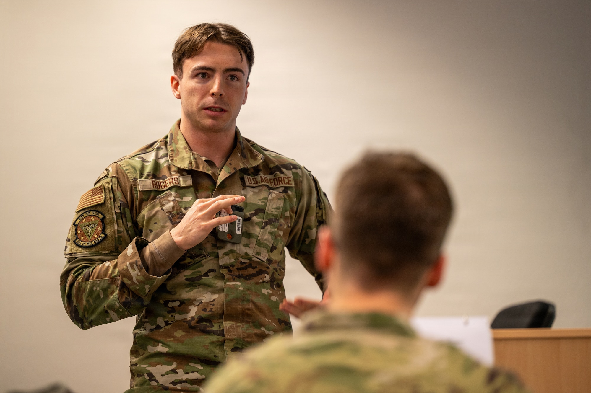 Senior Airman Devin Rogers, 86th Operational Medical Readiness Squadron readiness non-commissioned officer in charge, discusses his proposed decontamination and response procedures with the participants of exercise Radiant Falcon at Ramstein Air Base, Germany, Feb. 12, 2026.