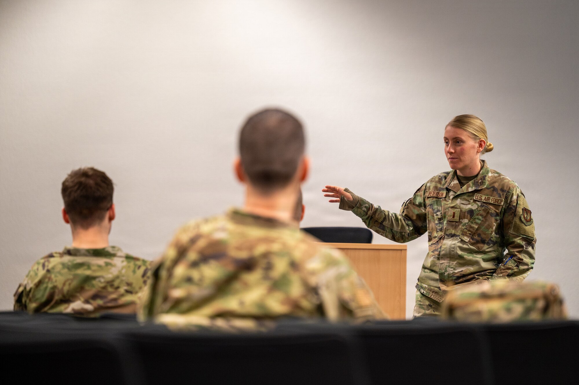 U.S. Air Force 2nd Lt. Allyson Peterson, 86th Operational Medical Readiness Squadron bioenvironmental flight officer in charge, briefs her proposed decontamination and response procedures to the participants of exercise Radiant Falcon at Ramstein Air Base, Germany, Feb. 12, 2026.