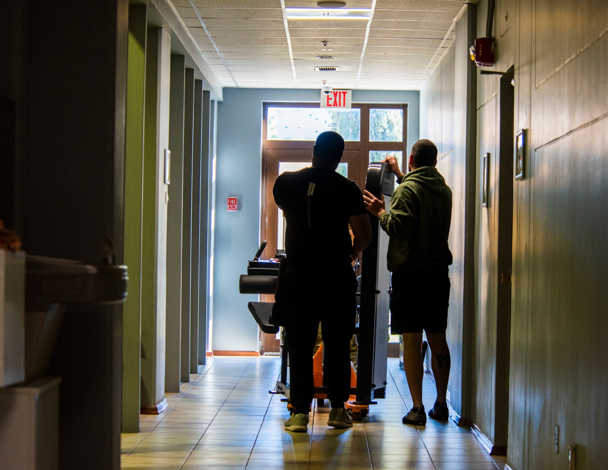 U.S. Airmen move gym equipment