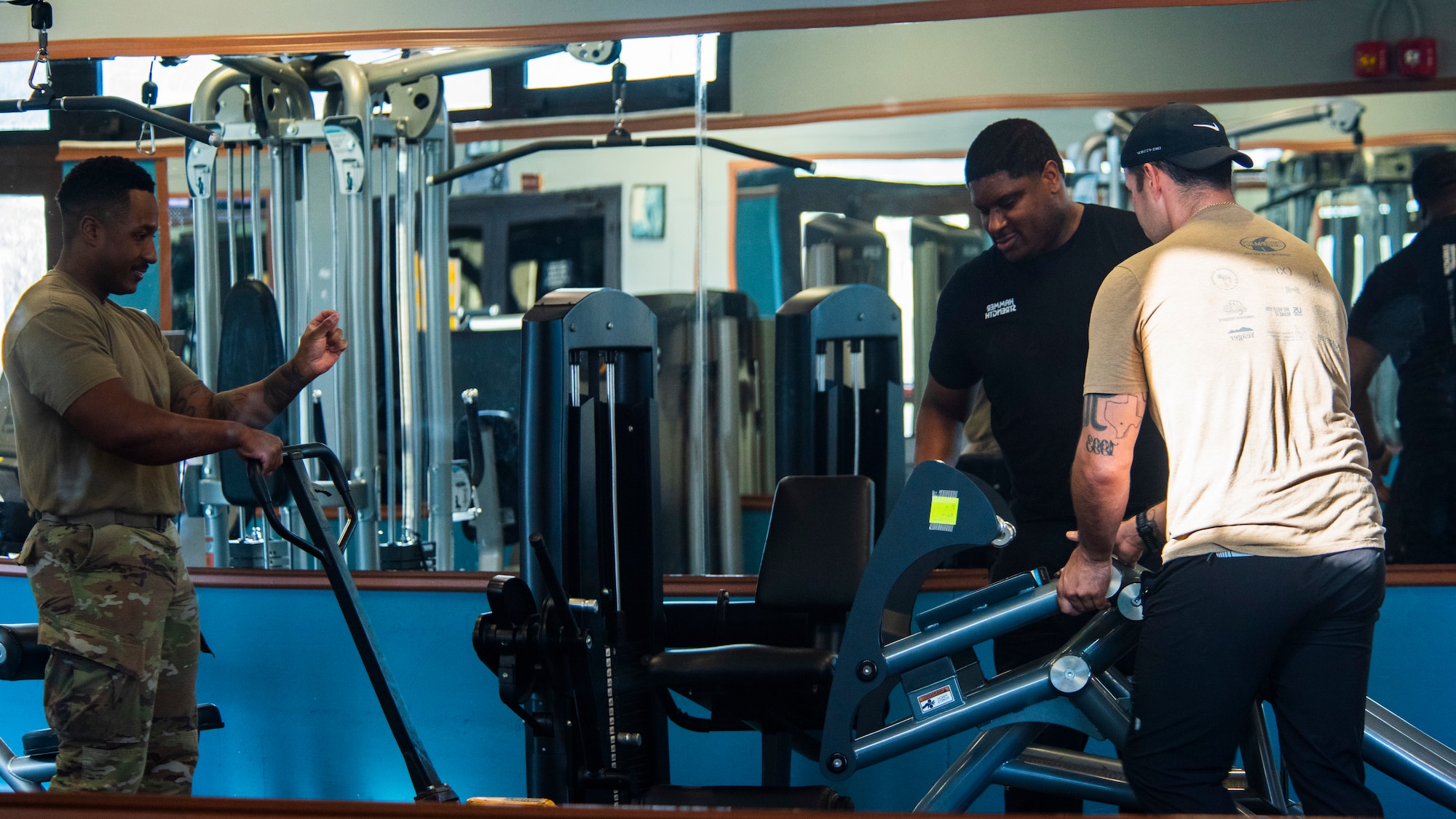 U.S. Airmen place a strength-training machine onto a pallet jack