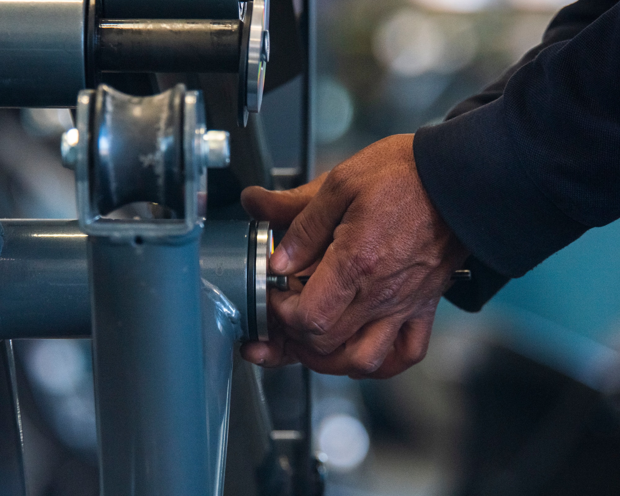 A member loosens a bolt on a strength-training machine