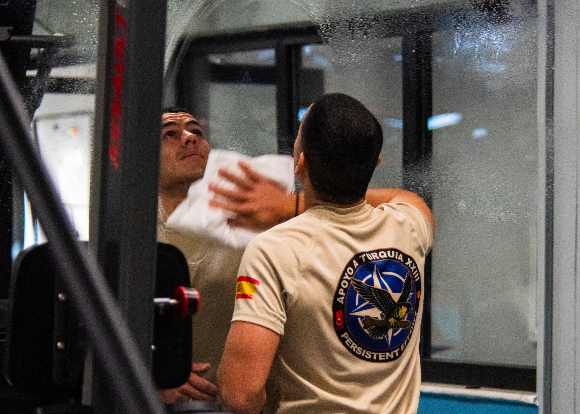 A Spanish Army soldier cleans a mirror