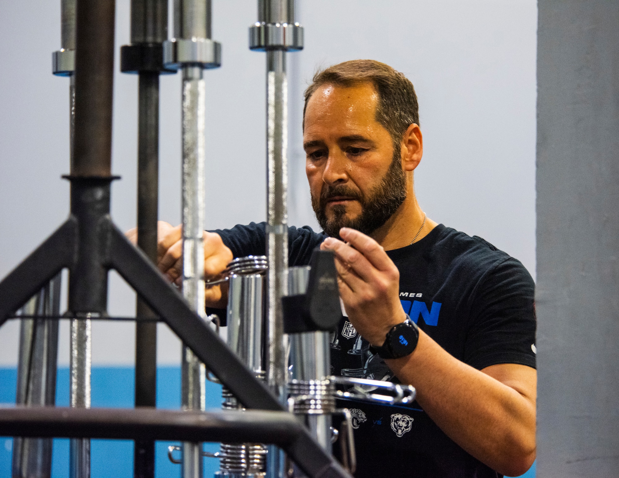 A Spanish Army soldier puts a weight stack retainer on a cable machine