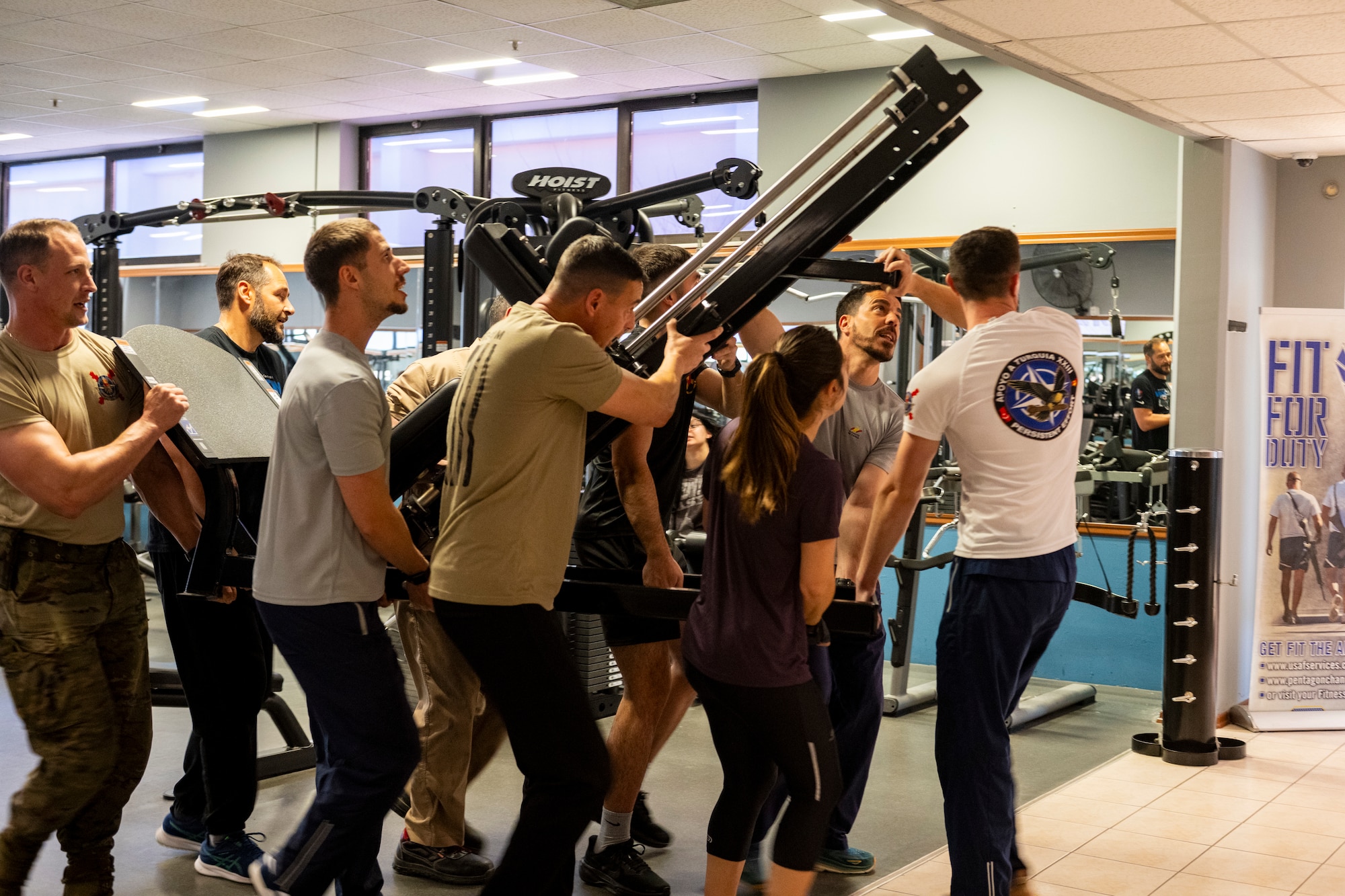 Spanish Army soldiers lift and move a strength-training machine