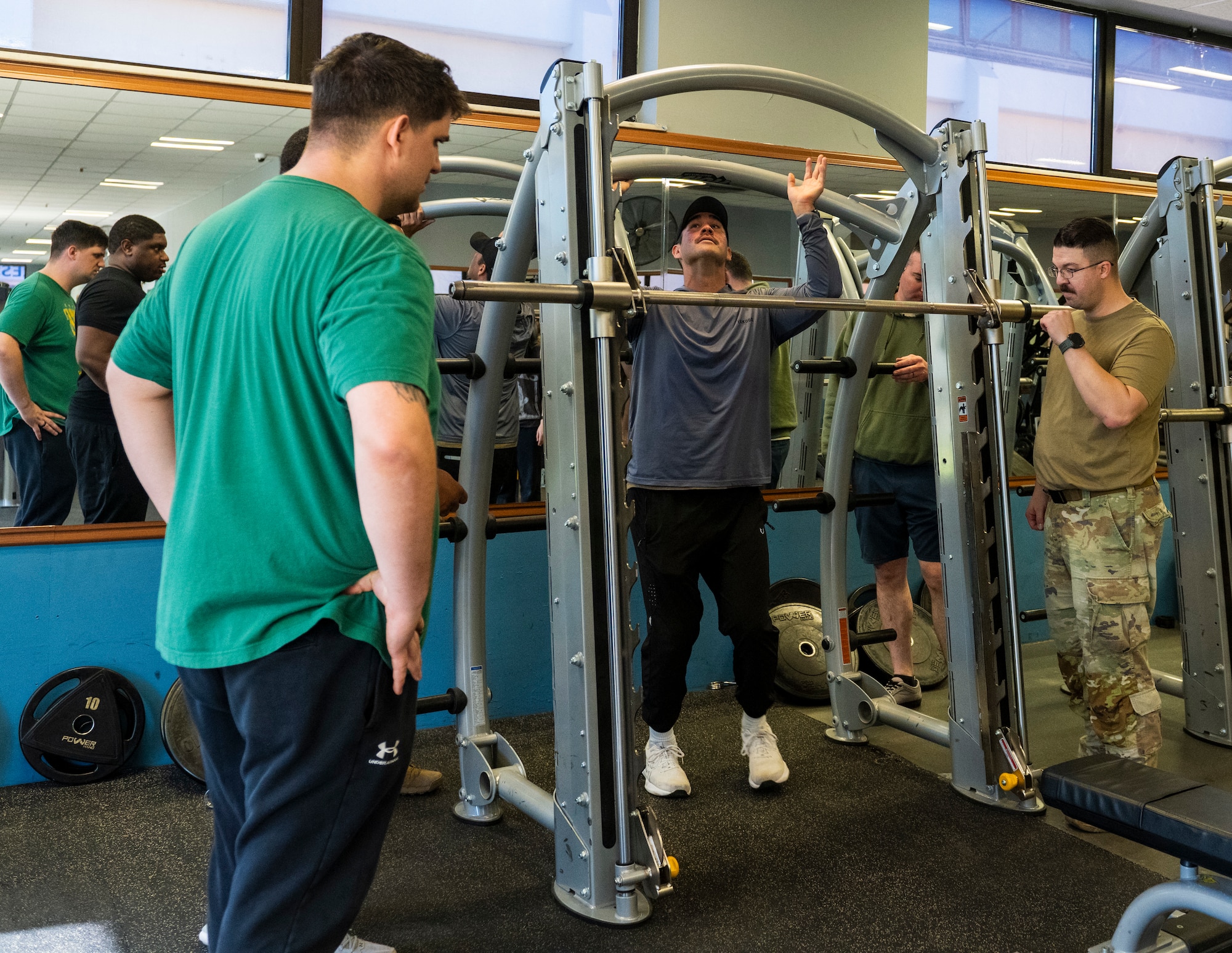 U.S. Airmen adjust and secure a strength-training rack