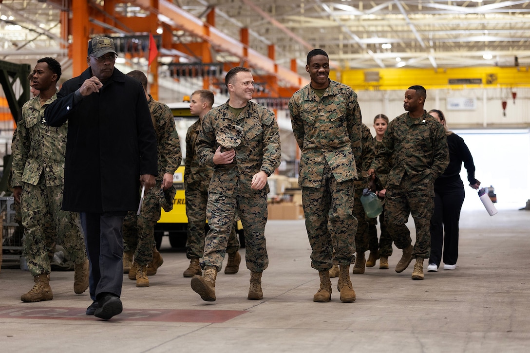 Retired Marine Corps Maj. Thurman Bobbett, head of the maintenance branch at Blount Island Command, leads Naval Reserve Officer Training Corps students through corrective and preventive procedures inside a warehouse Feb. 23, 2026, at Marine Corps Support Facility Blount Island, Florida. Gunnery Sgt. John Lambert, who completed Officer Candidates School and is scheduled to commission as a second lieutenant after earning his degree in December, walks beside Midshipman 4th Class Chance Anderson of Warner Robins, Georgia. (Official Marine Corps photo by Dustin Senger)