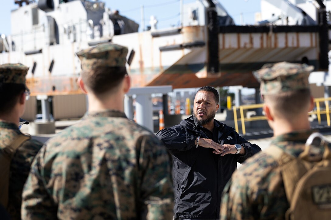 Retired Navy Chief Warrant Officer 5 Cary Carrigan, a contracted logistics specialist at Blount Island Command, briefs Naval Reserve Officer Training Corps students Feb. 23, 2026, at Marine Corps Support Facility Blount Island, Florida, on shipyard operations and the Improved Navy Lighterage System, a modular ferry system that enables ship-to-shore cargo movement in austere environments. (Official Marine Corps photo by Dustin Senger)