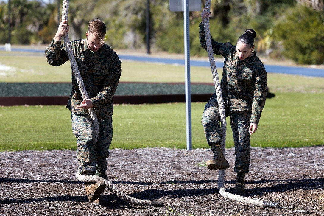 Midshipman 2nd Class Caedon Hampton of Groveland, Florida, listens as Marine Corps Sgt. Elizabeth Diazpilier of New York City explains the rope obstacle during a Blount Island Command-hosted demonstration Feb. 23, 2026, at Marine Corps Support Facility Blount Island, Florida. The event highlighted combat fitness and leadership development expected of future Marine officers. (Official Marine Corps photo by Dustin Senger)